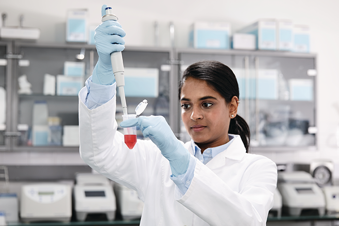 Scientist filling up a conical tube